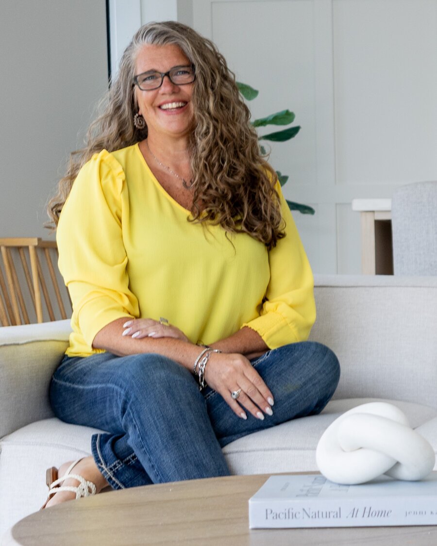 Smiling portrait in a white knit top, glasses, soft daylight
